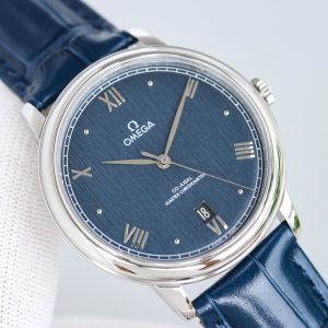 Alternative view of BLS Omega De Ville Collection     This original molded Master Chronometer watch is crafted from stainless steel. Its arched dial features deep blue PVD coating with irregularly arranged vertical textures, creating a sunray-brushed finish. Particularly striking are the rhodium-plated hands, alternating Roman numerals, and cabochon-set hour markers.A date window is positioned at the 6 o'clock mark, while the dial is adorned with a "railway" minute track, complementing the watch's minimalist aesthetic. It is fitted with a stainless steel bracelet. Clasp type: butterfly clasp. Powered by the Omega 8800 Master Chronometer movement with a black balance wheel, the movement's elegant operation is clearly visible through the scratch-resistant sapphire crystal caseback.